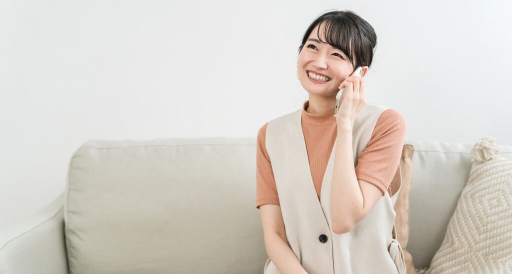 ##職場における電話の基本原則と重要性 ###電話のかけ方が左右するコミュニケーションの質 職場の電話は非対面で行われるため、声のトーン、言葉の選び方、応答の速さがコミュニケーションの質に大きく影響する。明るく力のある声は相手に安心感を与える一方、曖昧な表現は誤解を招きやすい。取引先への初回電話では企業の第一印象を左右し、上司への連絡では自身の責任感が評価される。さらに、電話による円滑なコミュニケーションは業務効率の向上に直結し、問題解決のスピードも高める。 ###基本原則：目的明確化・準備万端・丁寧さ 職場での電話には、「目的明確化」「準備万端」「丁寧さ」の三原則がある。 目的明確化：通話前に「何を伝えるか」「何を聞きたいか」「どの程度の時間が必要か」を確認する。 準備万端：必要資料（顧客データ、会議メモなど）、メモ用紙、ペンを手元に用意し、万一の転送や不在時の対応も想定する。 丁寧さ：挨拶の徹底、相手の話を最後まで聞く姿勢、感謝の言葉の表現などで示し、常に相手の立場を配慮する。 ###電話のタイミング選びのポイント 電話のタイミングは相手への配慮を示す重要な要素である。取引先への電話は通常の就業時間（9時～17時）の中でも、開店直後（9時～10時）や閉店直前（16時～17時）は避ける。会議が多い午前中は短時間で済む内容に限定し、詳細な協議は午後の余裕のある時間帯を選ぶ。上司への連絡は、朝の出社直後や退社前の繁忙期を避け、可能であれば事前に「今、電話してもよろしいですか？」と確認する。緊急時は例外だが、事前に簡単なメールで予告しておくのが望ましい。 ###声のトーンと言葉遣いの基本ルール 電話では声が「顔」となるため、トーンと言葉遣いには細心の注意が必要である。声のトーンは明るく、はっきりと、力を込めすぎず落ち着いたものが理想的。早口では内容が伝わりにくく、遅すぎると相手に退屈感を与えるため、適切なスピードを保つ。言葉遣いは「です・ます調」を徹底し、取引先には敬称（「〇〇様」）を使用する。「あいまい」「多分」「しかし」などの消極的表現は避け、「確かに」「了解いたしました」「今すぐ対応いたします」など明確な表現を用いる。 ###電話メモの正しい取り方と管理法 電話メモは業務記録として重要であり、「5W1H」（いつ、誰が、どこで、何を、なぜ、どうやって）を必ず記載する。基本項目は、通話日時、相手の氏名・所属・役職、電話番号、通話内容（伝達事項、依頼事項、約束事項）、対応者の氏名である。メモは簡潔かつ正確に記述し、後で見返しても理解できるようにする。管理法としては、専用の電話メモ帳を使用し、日付ごとに整理、プロジェクト別にフォルダ分けする。重要なメモはスキャンしてデジタル保存し、一定期間保管する。 ##電話をかける前の準備と基本的な手順 ###通話目的の明確化と要点整理 電話をかける前に、通話目的を具体的に明確化し、要点を整理する。目的は「報告」「依頼」「確認」「提案」「謝罪」などに分類し、例えば「A社の〇〇様に新商品のプレゼンテーション日程を提案する」と明記する。要点整理では、目的達成に必要な情報をリスト化する。提案の場合は「プレゼン候補日程（3案）」「プレゼン概要」「必要時間」「問い合わせ窓口」などを挙げる。相手からの反論や質問も想定し、事前に回答を準備しておくことで、臨機応変に対応できる。 ###相手情報の確認と背景調査 通話前に相手情報と背景を確認することで、信頼関係構築につながる。基本情報として氏名、所属、役職、電話番号を正確に確認し、誤読や誤記を避ける。初回接触時は、相手企業の事業内容、最近のニュース（新製品発売、業績発表など）、業界動向を調べておくとよい。例えば「先日発売された貴社の新製品は好評だと聞いております」と話題をつなぐと会話がスムーズになる。既存取引の場合は過去の通話記録や契約内容を確認しておく。 ###必要な資料とツールの準備 通話中の円滑な進行のため、資料とツールを事前に準備する。資料としては、相手企業のプロフィール、過去の取引履歴、プレゼン概要、価格表、納期表などがある。手元に置き、必要箇所に印をつけておくと効率的である。ツールとしてはメモ用紙（または電子メモアプリ）、ペン、タイマー（長時間通話回避用）、スマートフォン録音機能（同意を得た上で後で確認用）などを用意する。複数の事項を伝達する場合はチェックリストを作成し、漏れを防ぐ。 ###基本的な通話手順：挨拶から閉めまで 職場電話の基本手順は「着信応答」「自己紹介」「相手確認」「目的説明」「本題」「確認」「挨拶で閉める」の順に行う。相手が出たら「はい、〇〇株式会社の△△です。本日はお時間をいただき、ありがとうございます。」と挨拶し自己紹介する。次に「〇〇様でいらっしゃいますか？」と確認し、「新商品のプレゼンテーション日程について、ご相談させていただきたいと思いました。」と簡潔に目的を説明する。本題後は「今伝えた内容でご理解いただけましたでしょうか？」と確認し、「何卒よろしくお願いいたします。」と挨拶して通話を終了する。 ###緊急時の電話かけ方の注意点 緊急時は「迅速性」「正確性」「冷静さ」が求められる。電話前に緊急事態の内容（何が、いつ、どこで、誰が、現在の状況）を整理する。相手が出たら「緊急事態が発生したため、急ぎご連絡いたしました。〇〇株式会社の△△です。」と伝え、自己紹介する。事態概要を簡潔かつ正確に説明し、「何をしていただけますか？」「どのように対処すべきでしょうか？」と具体的に依頼する。通話中は冷静さを保ち、相手の指示を正確に聞き、最後に「〇〇を行うことを確認いたしました。ありがとうございます。」と確認して終了する。 ##相手別の電話かけ方ガイド ###取引先（新規・既存）への電話かけ方 取引先への電話は、新規と既存でアプローチを変える。新規取引先には「貴社の事業内容を拝見し、当社製品がニーズに合致すると考え、ご連絡いたしました。」と理由を説明し、相手の時間を確認してから本題に入る。既存取引先には「いつもご高配を賜り、ありがとうございます。先日ご注文いただいた商品の納期についてご連絡いたしました。」と過去取引に触れ、親しみやすい雰囲気を作る。どちらも相手の意見を尊重し「ご意見をお聞かせいただけますか？」と積極的に傾聴し、最後に「本日はご時間をいただき、ありがとうございました。」と感謝する。 ###上司への電話かけ方と報告の仕方 上司への電話は、敬意を示しつつ明確に情報を伝える。事前に「今、電話してもよろしいですか？」と確認できれば確認する。電話に出たら「〇〇部長、お世話になっております。△△です。」と挨拶し、「先日ご指示いただいたプロジェクトの進捗状況をご報告いたします。」と目的を説明する。報告は「結論先行型」で「プロジェクトは計画通り進行しており、来月の納期は達成可能です。」と結論を述べ、続いて具体的なデータや課題を伝える。課題がある場合は「以下の対処案を考えていますが、ご指示を賜りますか？」と提案し、最後に「ご確認いただき、ありがとうございます。」と締める。 ###同僚や部下への電話かけ方 同僚や部下への電話は、親身かつ効率的に行う。同僚には「お世話になっております。△△です。今、お時間ありますか？」と確認後、「Aプロジェクトのデータを共有したいのですが、よろしいですか？」と目的を説明する。意見交換が必要な場合は「私の考えはこうですが、どう思いますか？」と話す。部下には指示前に「〇〇ですか？今から指示しますので、メモを取ってください。」と伝え、指示は具体的かつ明確にする。確認は「以上の指示で理解できましたか？」と行い、部下からの報告は「詳しく聞かせてください。」と傾聴する。 ###外部機関（行政・ベンダー）への電話かけ方 外部機関への電話は、機関の特性に合わせた丁寧さと正確性が重要である。行政機関（役所、税務署など）には「はい、〇〇株式会社の△△です。〇〇申請について手続きのご相談をさせていただきたいと思います。」と自己紹介と目的を明確にする。専門用語が多いため、不明点は「すみません、もう一度説明していただけますか？」と聞き返す。ベンダー（仕入先、サービス提供者）には「いつもご協力いただきありがとうございます。△△です。先日注文した商品の納期が遅れているようで、確認させていただきます。」と挨拶し、問題点や依頼内容を具体的に伝える。契約内容に関することは、事前に契約書を確認してから電話する。 ###海外の相手への電話かけ方のポイント 海外の相手への電話は、時差、言語、文化の違いを考慮して準備する。まず時差を正確に確認し、相手の就業時間内に電話する。例として、アメリカ（ニューヨーク）とは13時間の時差があり、日本の夜は相手の朝に当たる。言語面では、英語が母語でない場合は簡単な単語と短文を使い、スピードを落とす。専門用語は日本語と英語の対訳を用意し、必要に応じて「〇〇という言葉でよろしいですか？」と確認する。文化面では相手国の敬語や挨拶習慣を調べ、欧米では最初に名前で呼ぶことが多い。通話前にメールで予告し、概要を送っておくと円滑に進む。 ##業務シーン別の電話対応テクニック ###新規顧客開拓のための電話かけ方 新規顧客開拓の電話は、相手の関心を引きつけることが最大の目的である。まず電話をかける前に、相手企業のニーズを分析し、自社の商品・サービスがどのようにそのニーズを満たすかを明確にする。通話では、最初に「貴社が〇〇分野で効率化を目指しているとお聞きしております。弊社の△△サービスが、その目標達成にお役立ちできる可能性があるため、ご連絡いたしました。」と、相手の関心に訴えかける。次に「1分ほどでサービス概要を説明させていただけますか？」と時間を確認し、核心的なメリット（コスト削減率、作業時間短縮効果など）を具体的に伝える。相手が興味を示した場合は「詳細資料を送付し、面談の機会をいただけますでしょうか？」と次のステップを提案する。 ###依頼・申請・確認のための電話かけ方 依頼、申請、確認の電話では、「何を」「誰に」「いつまでに」を明確にすることが重要である。 依頼の場合：「〇〇様、お世話になっております。△△です。Aプロジェクトのデータを明日の午前中に共有いただけますか？ご都合が悪ければ、調整可能な時間をお知らせください。」と依頼内容と期限を伝え、柔軟性を持たせる。 申請の場合：「〇〇役所△△課ですか？〇〇株式会社の□□です。新規事業の許可申請について、手続き方法を確認させていただきます。」と申請内容を明記し、必要書類、提出期限、手数料などを具体的に聞く。 確認の場合：「先日ご連絡した納期変更の件について、ご承認いただけましたでしょうか？」と対象事項を明確にし、回答を確認後にメモする。 ###クレーム・苦情への電話対応術 クレームや苦情対応は、「傾聴」「謝罪」「原因究明」「対処案提示」の順で進める。 まず相手の不満を最後まで傾聴し、途中で遮らない。話が終わったら「本日はご迷惑をおかけいたしました。心よりお詫び申し上げます。」と真摯に謝罪する。次に「内容を確認させていただきます。〇〇の点でご不満とのことですね？」と正確に把握し、「原因を調査し、1時間以内にご連絡いたします。」と対応時間を明記する。調査後は「原因は〇〇でした。対処案として、1.商品の交換 2.割引 の二案があります。どちらをご希望ですか？」と具体案を提示し、相手の同意を得て迅速に対応する。最後に「今後は再発防止に努めます。本日はご理解いただき、ありがとうございます。」と感謝を伝える。 ###会議の手配・変更のための電話かけ方 会議の手配・変更は、正確性と柔軟性が求められる。 手配の場合：「〇〇様、お世話になっております。△△です。来週水曜日午後2時から、Aプロジェクト進捗会議を開催したく、ご都合を確認させてください。」と目的と候補日時を伝える。複数関係者がいる場合は各自の予定を確認した上で、共通の空き時間を提案する。 変更の場合：「急ぎのご連絡です。△△です。来週水曜日の会議ですが、上司の都合により木曜日午後2時に変更させていただきます。ご都合はいかがでしょうか？」と理由を簡潔に説明し、新日時を提案する。全員の同意後は「会議の変更について、メールで正式に確認を送付いたします。」と連絡する。 ###緊急事態発生時の電話連絡法 緊急事態（事故、災害、システム障害など）の電話連絡では、迅速かつ正確な情報伝達が求められる。まず連絡先（上司、関係部門、外部機関など）を明確にし、優先順位を決める（例：上司→関係部門）。上司への報告例：「〇〇部長、緊急事態が発生しました。△△です。午前10時にBシステムが停止し、全受注処理ができません。影響範囲は全店舗で、復旧予定は未定です。」次に「システムベンダーへの連絡準備が整いました。ご指示をいただけますか？」と具体的な対応案を提案し、指示に従う。進捗は定期的に報告し、復旧後は「Bシステムは午後1時に復旧し、受注処理を再開しました。今後の予防策を検討します。」とまとめる。 ##電話コミュニケーションの高度化と信頼構築 ###傾聴力の向上：相手の話を正しく理解するコツ 電話での傾聴力は、相手の意図を正確に理解するために不可欠である。 積極的な応答：話の途中で「はい」「了解しました」「そうですか」などの間投詞を入れ、関心を示す。 繰り返し確認：重要情報を聞いた後に「〇〇を行う、ということで間違いないですか？」「期限は明日午後5時までですね？」と繰り返し確認する。 質問をする：「この点について、もう少し詳しく教えていただけますか？」と具体的に問い、意図を明確にする。 主観を入れない：話の途中で判断せず、最後まで聞き終えることが重要である。 ###非言語コミュニケーションの活用：声と沈黙の使い方 電話では対面の表情やジェスチャーが使えないため、声と沈黙で非言語コミュニケーションを補う。 声の活用：トーンで感情を伝える。報告は落ち着くトーン、感謝は温かく、緊急時は速く冷静に。音量は相手が聞きやすいよう調整し、重要情報はやや大きめにする。 沈黙の活用：相手が考える時間を与え、提案後に「ご意見をお待ちしています。」と伝えて沈黙する。長すぎる沈黙は避け、3～5秒で次の話題に移る。 ###電話後のフォローアップの重要性と方法 電話後のフォローアップは、コミュニケーションの完結と信頼構築に重要である。基本はメールによる確認で、通話内容や約束事項、指示などをまとめて送付する。「本日は電話でご連絡いたしました△△です。内容をまとめさせていただきます。」と記載する。会議の手配では日時、場所、参加者、議題をメールで共有する。依頼内容は「ご依頼のAデータを明日中に提出します」と確認し、クレーム対応では経過報告と解決後の感謝メールを送る。フォローアップは原則24時間以内に行う。 ###電話コミュニケーションの失敗事例と反省点 失敗事例から学ぶことでスキルを向上できる。 事例1：相手の氏名を間違える → 電話前に情報確認、通話中も「〇〇様でいらっしゃいますか？」と確認。 事例2：重要情報を伝え忘れる → チェックリストを作成し、通話中に逐次確認。 事例3：クレームで防御的に反論 → まず謝罪し感情を汲み取り、後に原因説明。 事例4：長時間話して目的が逸れる → 通話前に時間配分を決め、「本日の話はこの点までにしましょうか？」と調整。 ###電話コミュニケーションスキルの維持と向上法 スキルは維持と継続的向上が必要である。 定期的な自己反省：通話後に「今日の良かった点」「改善点」を簡単にメモ。 先輩や上司の対応を参考にする：声のトーン、言葉遣い、対処方法を観察。 ロールプレイングの実施：クレーム対応や新規顧客開拓を同僚とシミュレーションしフィードバックを受ける。